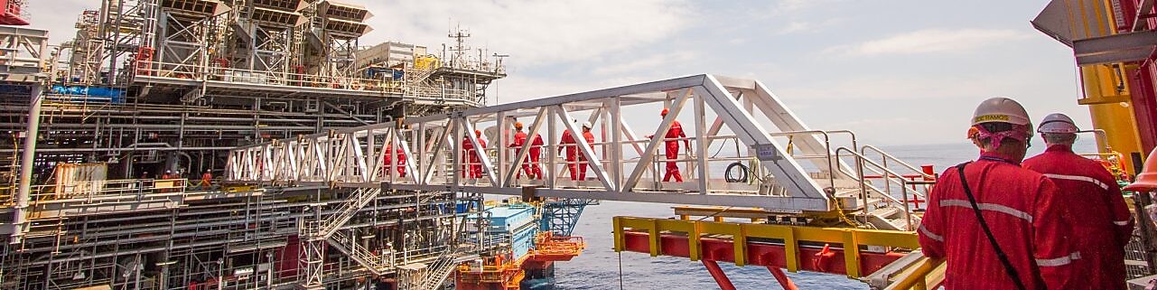 Puntorë të cilët janë duke kaluar mbi një platformë kompresioni të ndërtuar sipër projektit ekzistues të ujit, Malampaya.