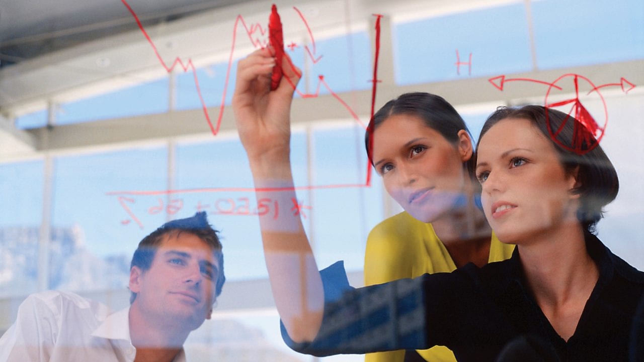 Një sipërmarrëse duke vizatuar grafikë në xham